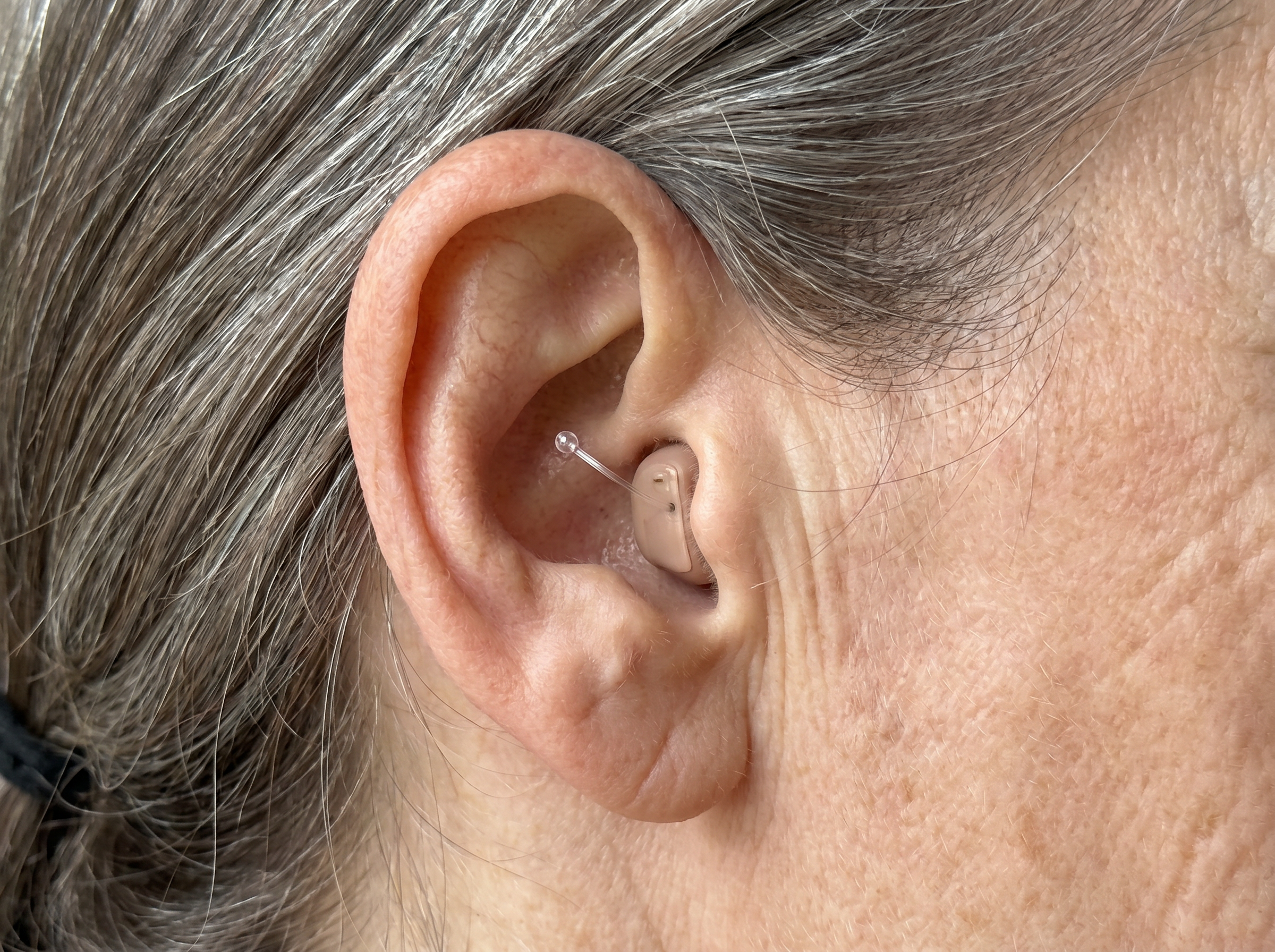 Close-up of the near-invisible in-ear amplifier in the ear